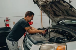 Looking for Honda Repairs? Enright Automotive is The Place to Go | Enright Automotive in Alexandria, OH. Image of Chris Enright checking and fixing a Honda car engine under the hood.