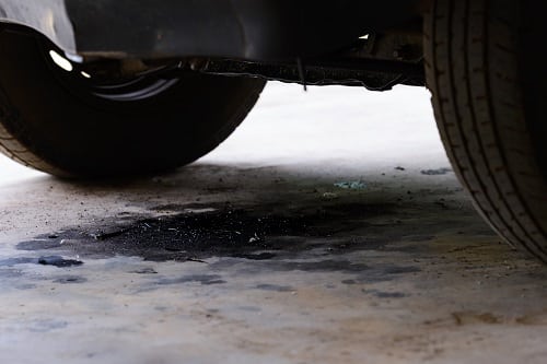 Spool Valve Oil Leak in Honda Odyssey & Pilot | Enright Automotive in Alexandria, OH. Image of an oil leak under a car.