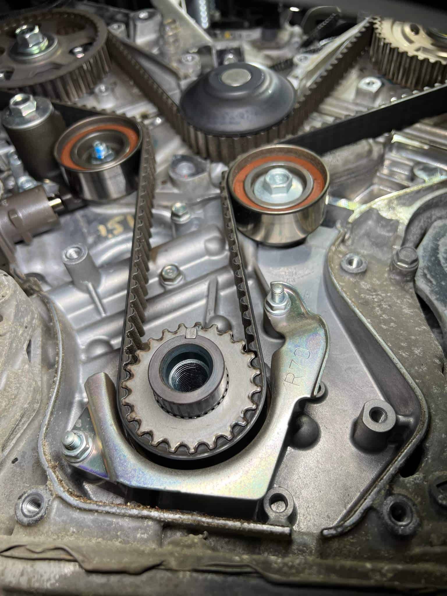 A closeup look at timing belt and other engine parts. Concept image of timing belt replacement at Enright Automotive.