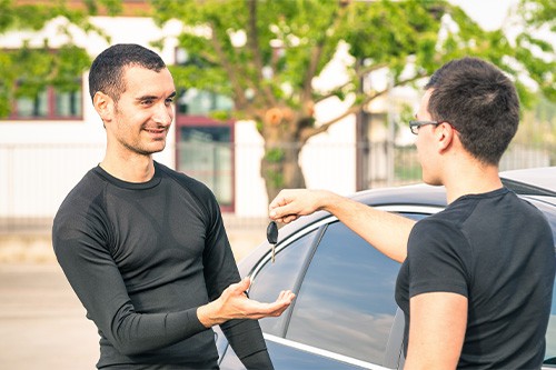 Is My Vehicle Worth Fixing? Hint: You'll Be Surprised! | Enright Automotive in Alexandria, OH. Image of a satisfied young man receiving car keys after second hand sale.
