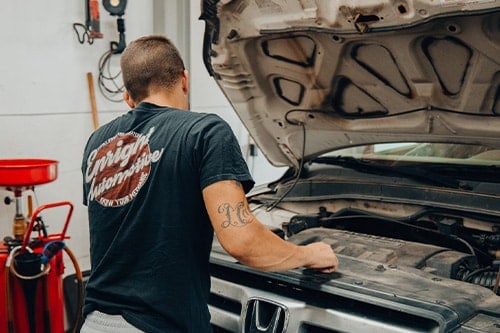 Chris Enright checking a car under the hood. Concept image of “Seriously...Are Preventative Maintenance Items Worth It?” | Enright Automotive in Enright, OH.