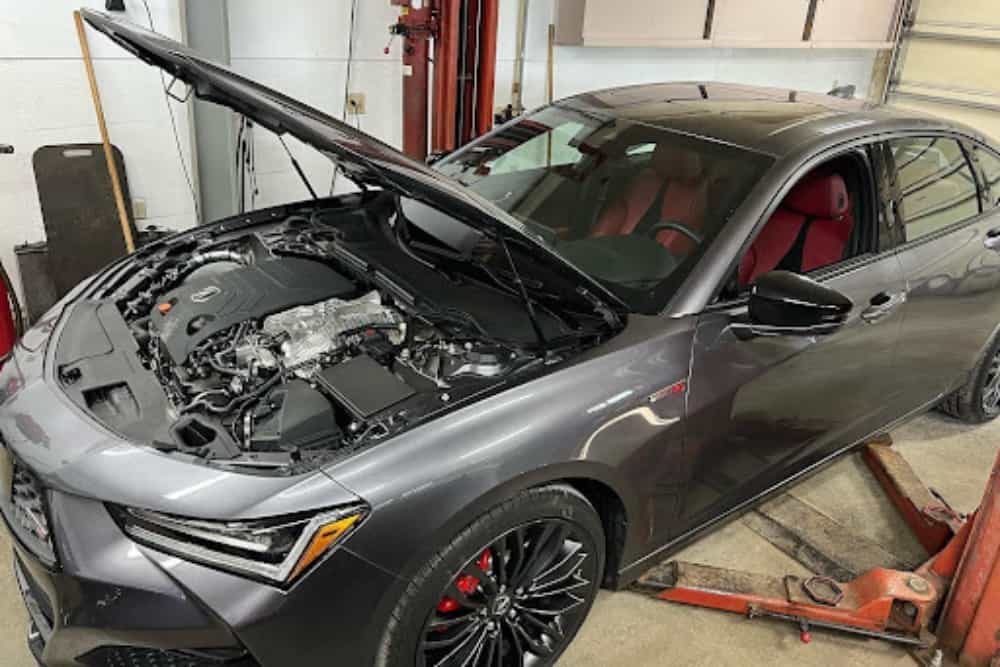 Acura repair specialist in Alexandria and Pataskala, OH with Enright Automotive. Image of gray newer acura performance car with hood open in shop.