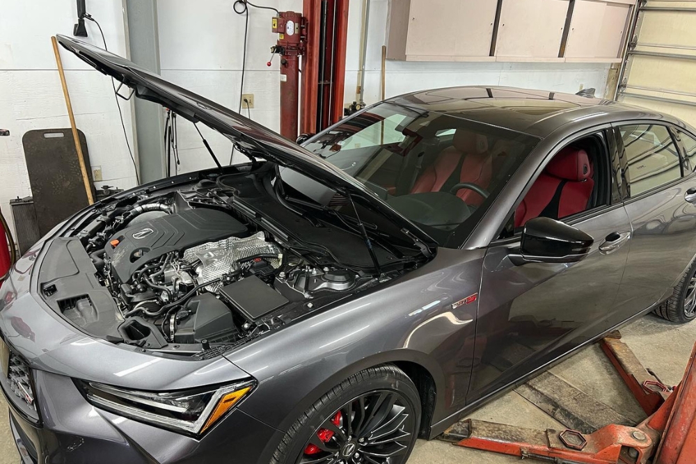 Winter Car Inspection in Alexandria OH At Enright Automotive. Acura car in an auto repair shop with the hood open during a car inspection.
