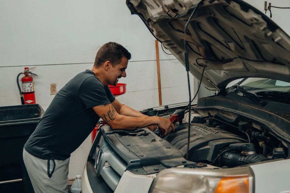 Japanese Auto Repair Service in Alexandria, OH At Enright Automotive. Mechanic performing maintenance on a white Honda at a Japanese auto repair shop.