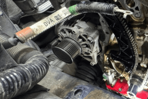Alternator repair, auto repair in Alexandria, OH, at Enright Automotive. Close-up of an engine with the timing cover removed, exposing the timing chain, guides, and alternator during a professional timing chain replacement and internal engine repair.