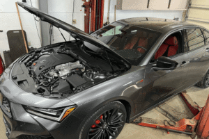 Auto repair shop warranty, auto repair in Alexandria, OH at Enright Automotive. Image of a gray Acura sedan with the hood open inside the repair shop, showing the engine bay during service.