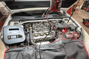 Honest auto repair in Alexandria, OH at Enright Automotive. Image of a vehicle engine bay connected to battery and diagnostic equipment during inspection and service.