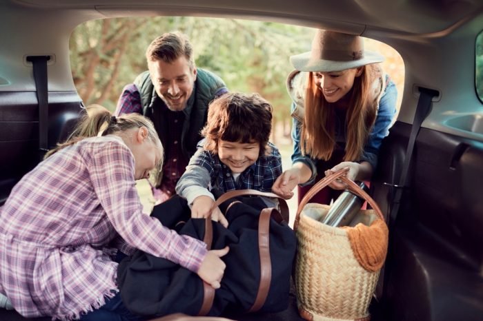 Reliable Honda Travel Tips for the Festive Season | Enright Auto Repair. Image of young family taking their bags out of vehicle.